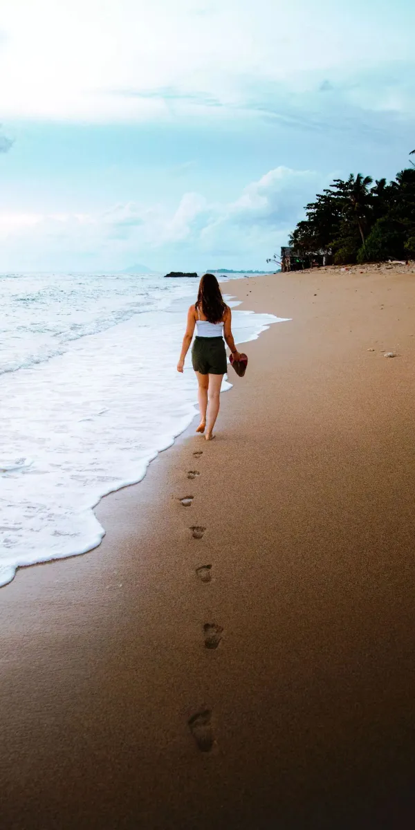 woman walking in front of beach wallpaper